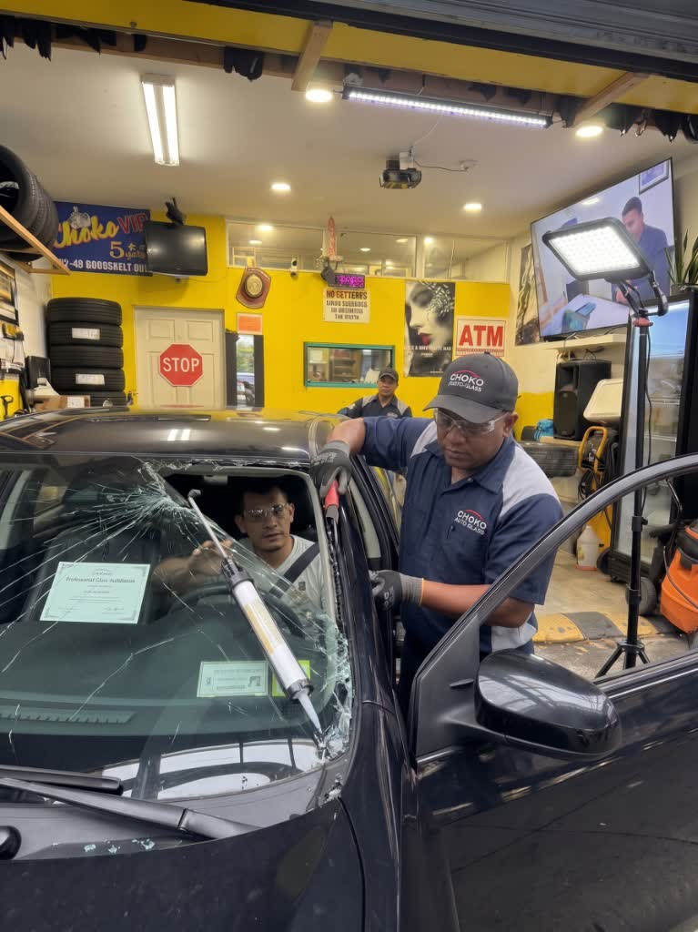 Técnicos reemplazando un parabrisas roto